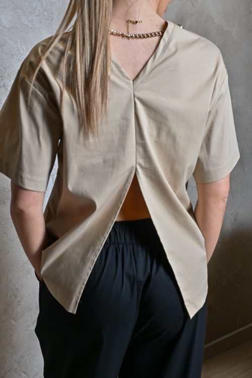Bež majica s lancem i prorezom na leđima – elegantna moderna majica